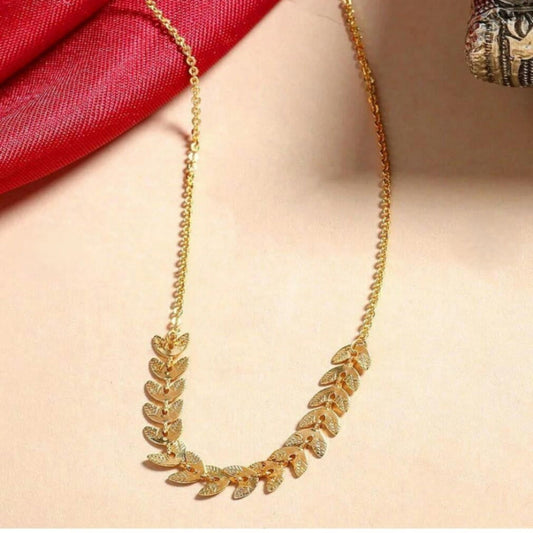 Gold necklace with leaf design on a plain background