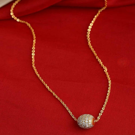 Gold necklace with a sparkling pendant on red fabric background