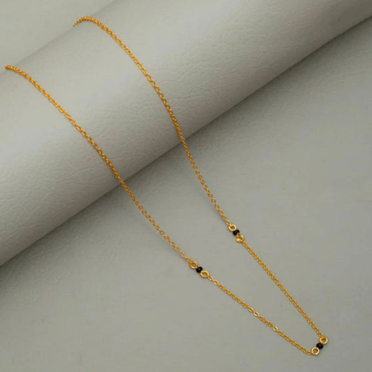 Gold necklace on a light gray background