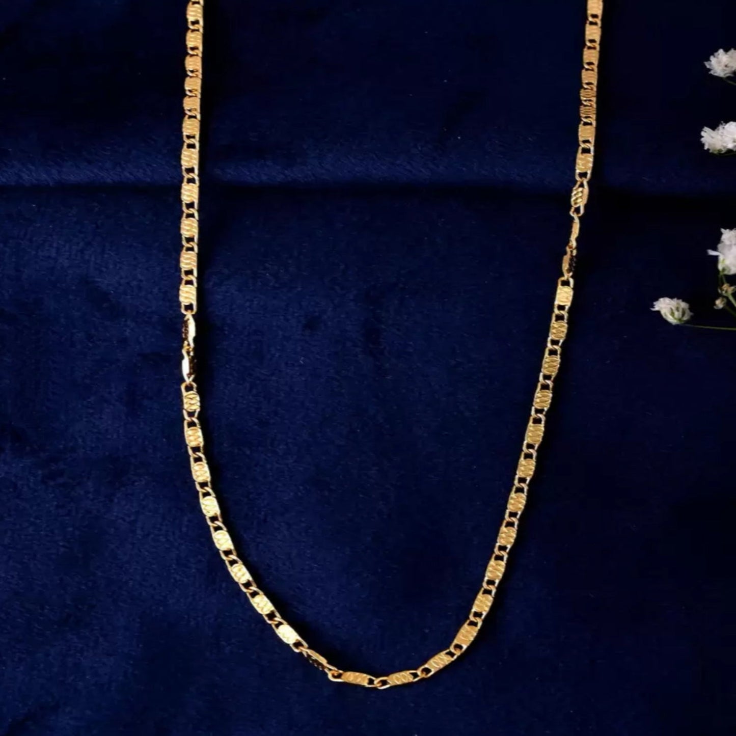 Gold chain on a dark blue fabric background