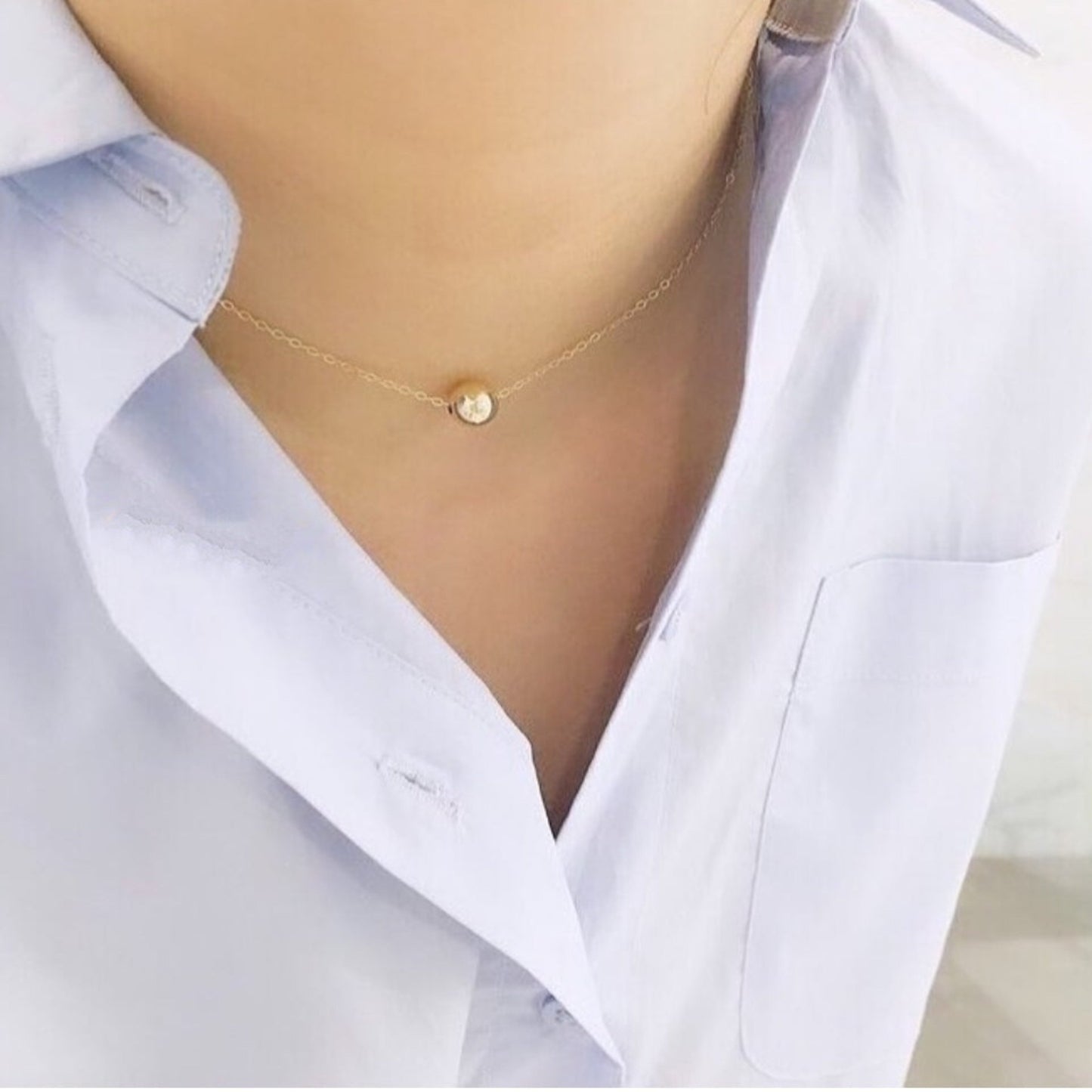 Gold necklace on a mannequin wearing a white shirt