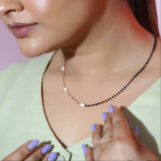 Close-up of a woman wearing a necklace with a pink background