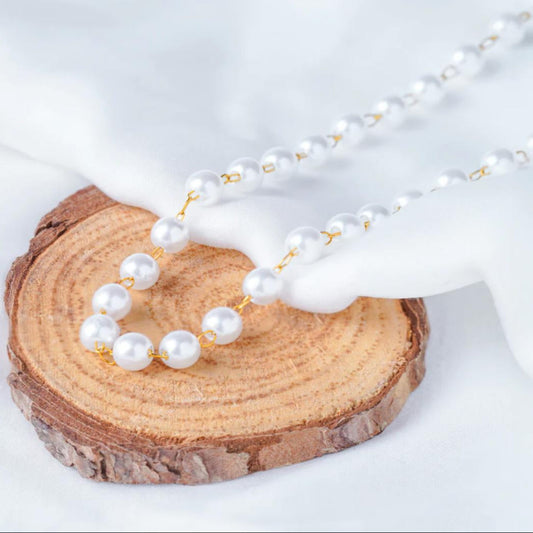 Pearl necklace on a wooden block with a white background