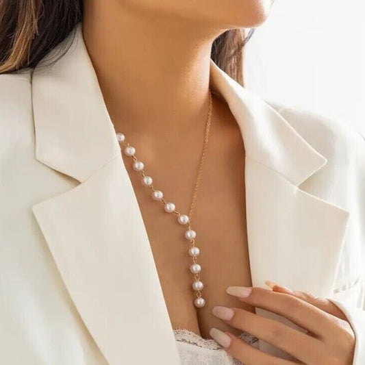 Pearl necklace worn by a person in a white blazer