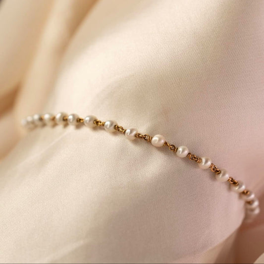 Pearl bracelet on a beige fabric background