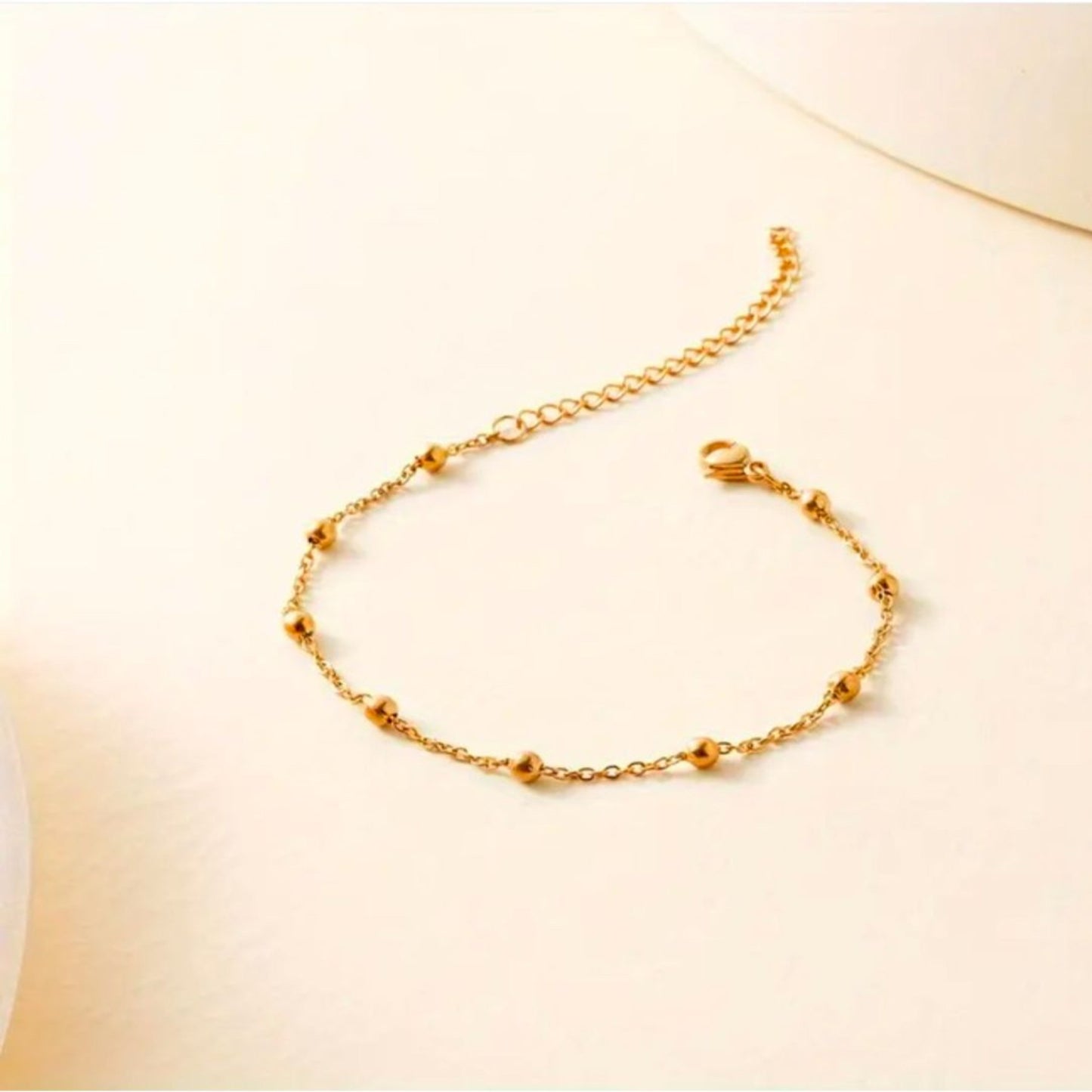 Gold bracelet on a light beige background
