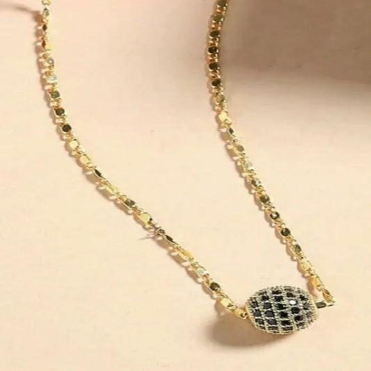 Necklace with a spherical pendant on a beige background