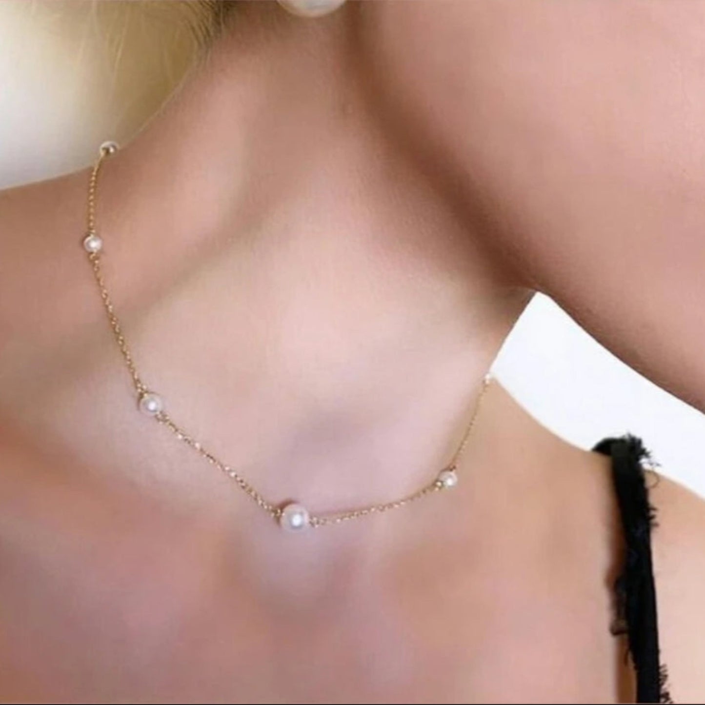 Pearl necklace worn by a person with a blurred background