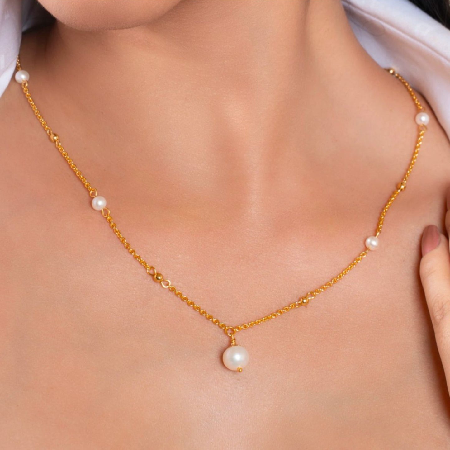 Gold necklace with pearls on a person's neck