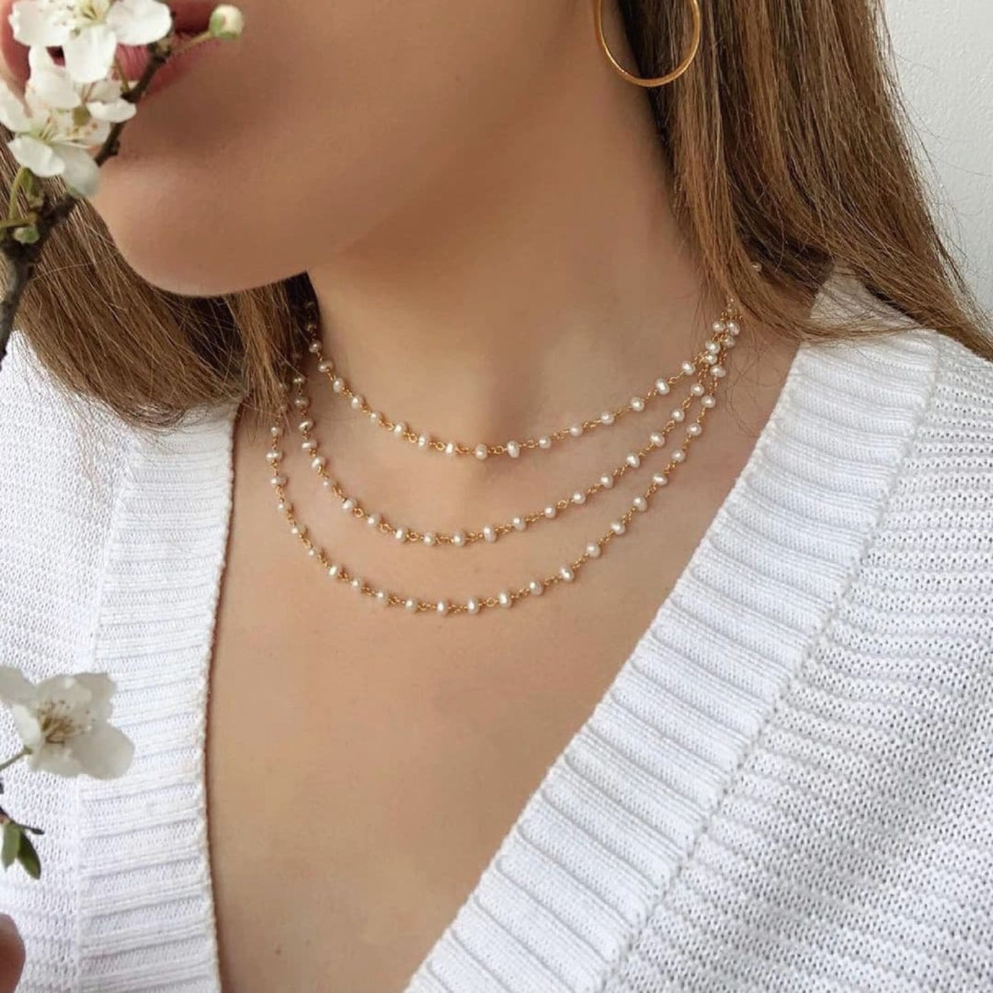 Close-up of a woman wearing a pearl necklace with a white background