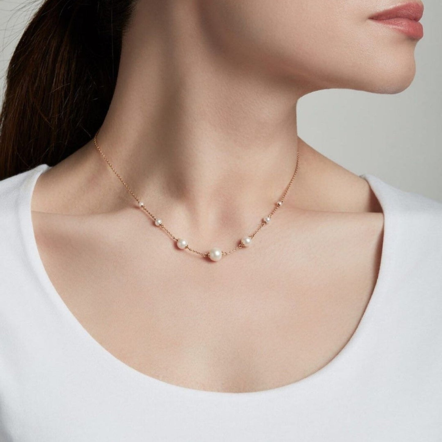Pearl necklace on a model against a neutral background