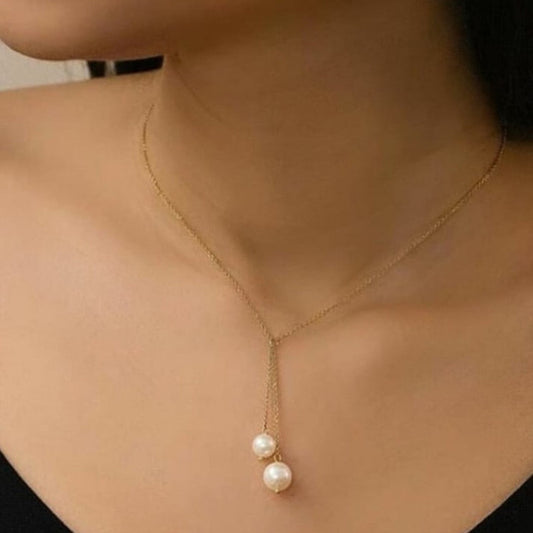 Gold necklace with pearl pendant on a person's neck