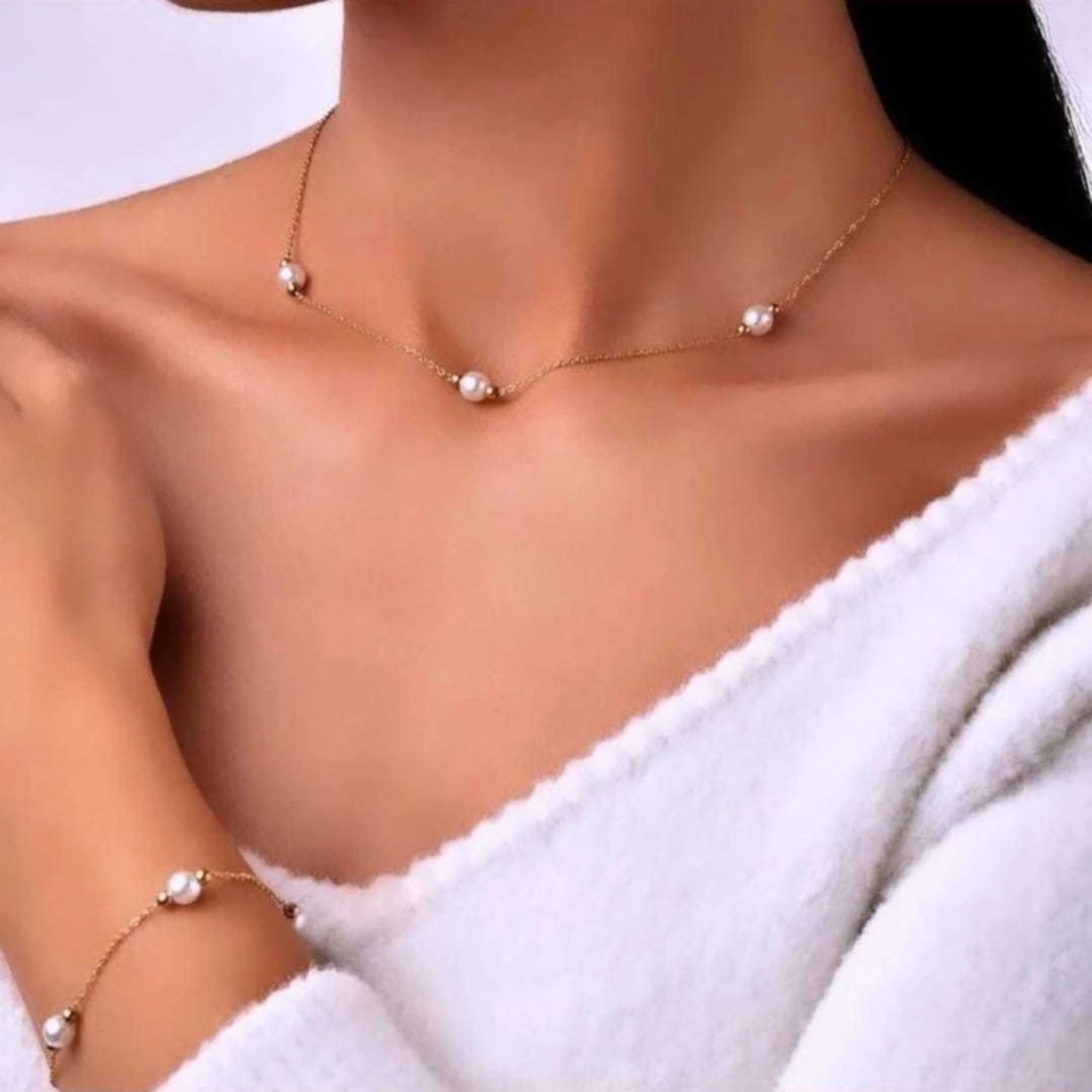 Pearl necklace and bracelet on a person wearing a white garment