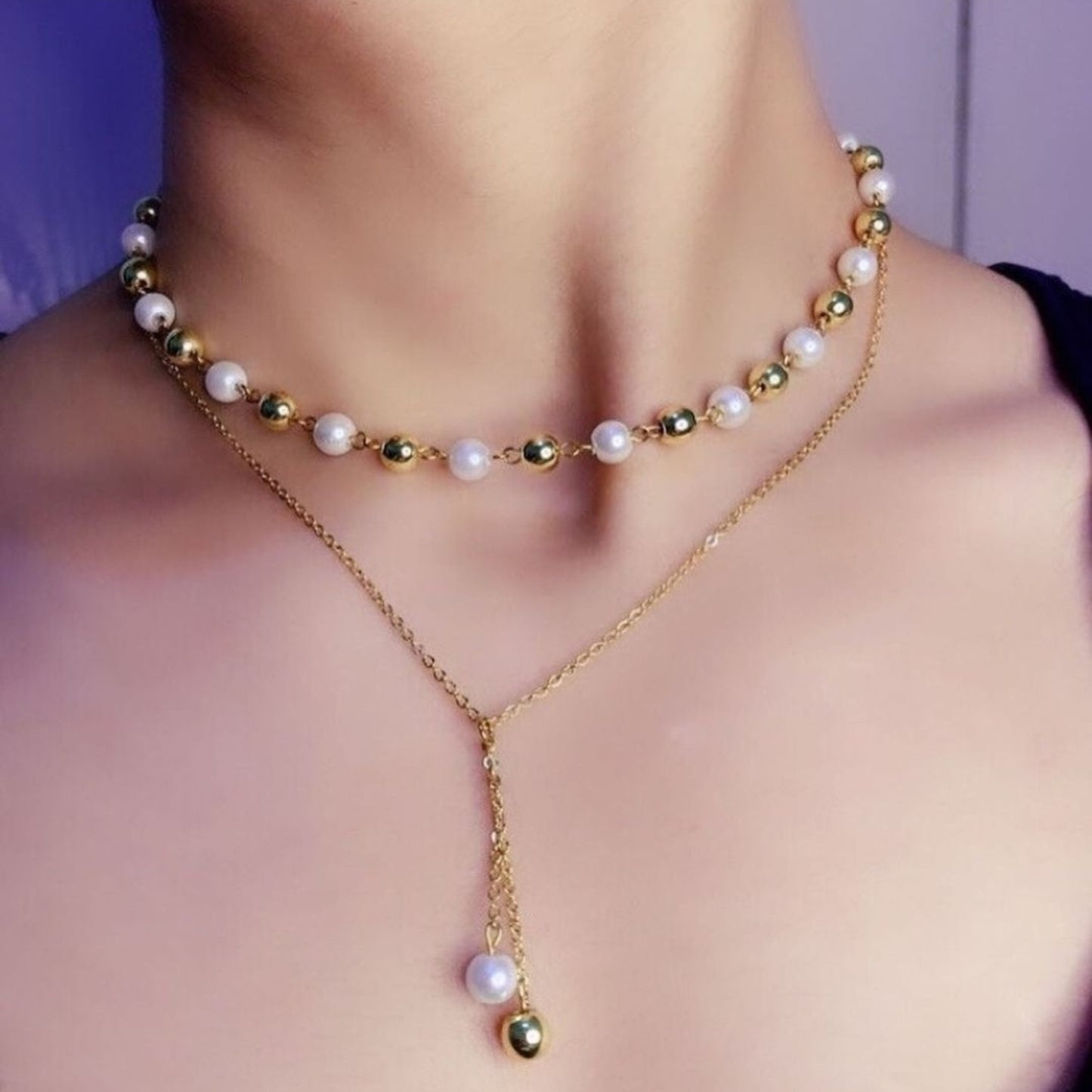 Gold and pearl necklace on a person's neck with a blurred background