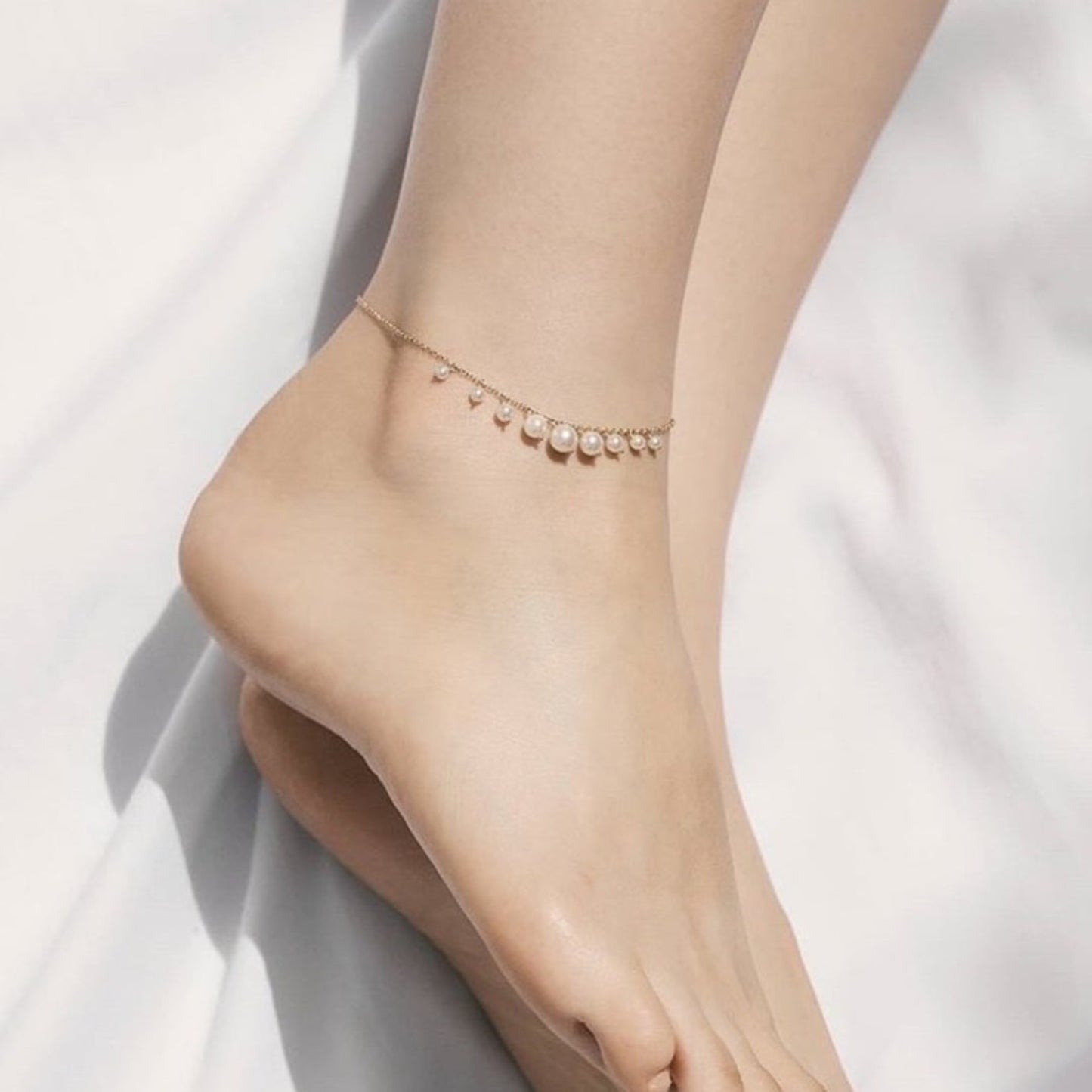 Ankle bracelet with pearls on a white background