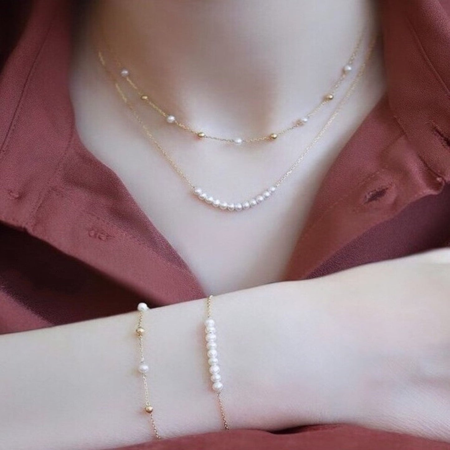 Pearl necklace and bracelet set on a mannequin with a pink background
