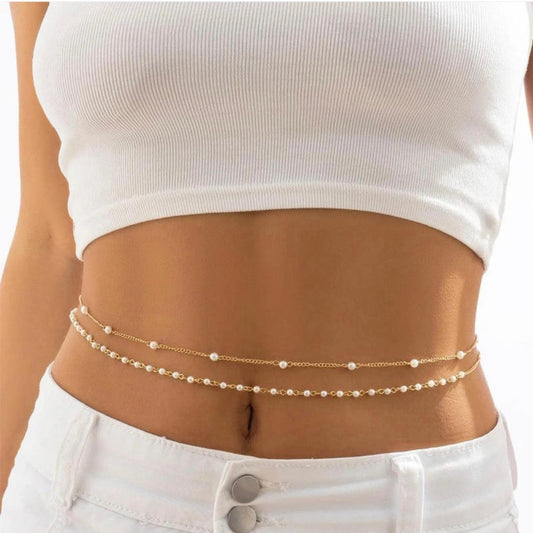 Person wearing a gold chain belt with a plain background
