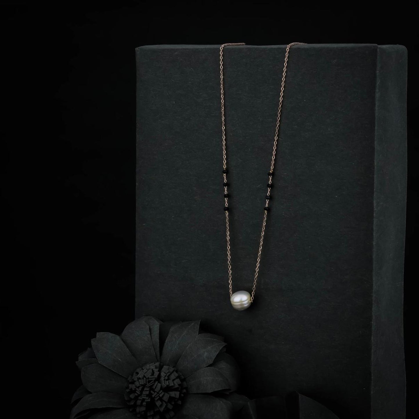 Necklace with a pendant on a black stand with a dark background