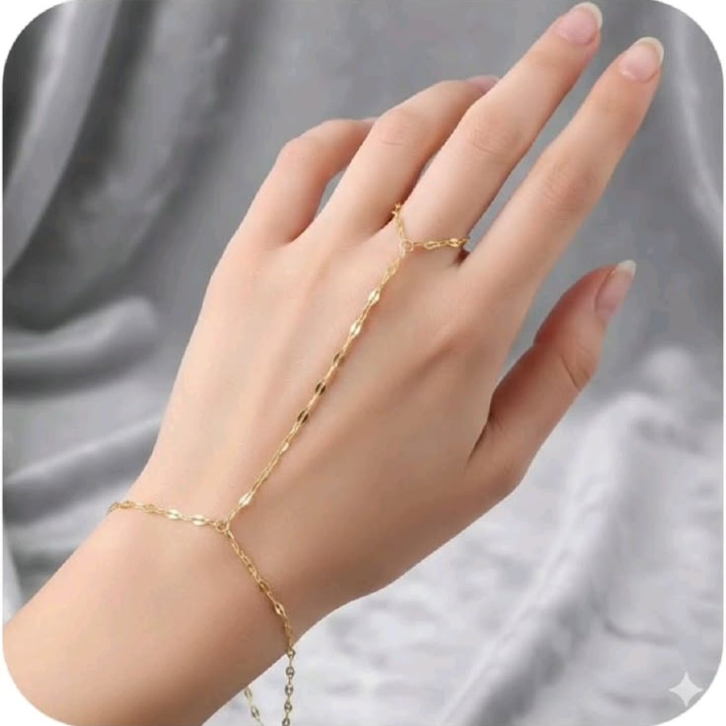 Gold bracelet on a hand against a gray background