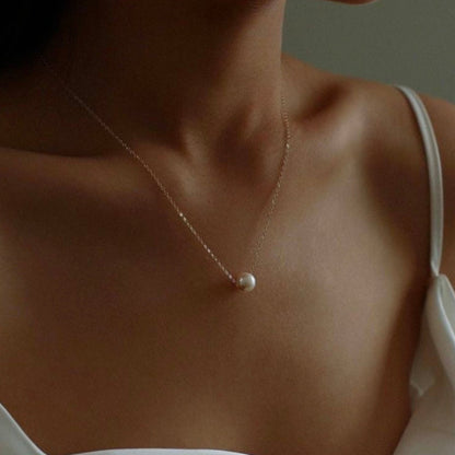 Woman wearing a delicate pearl necklace.