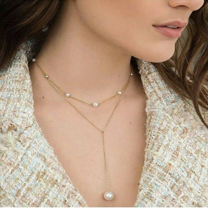 Woman wearing a delicate pearl necklace with a tweed jacket.