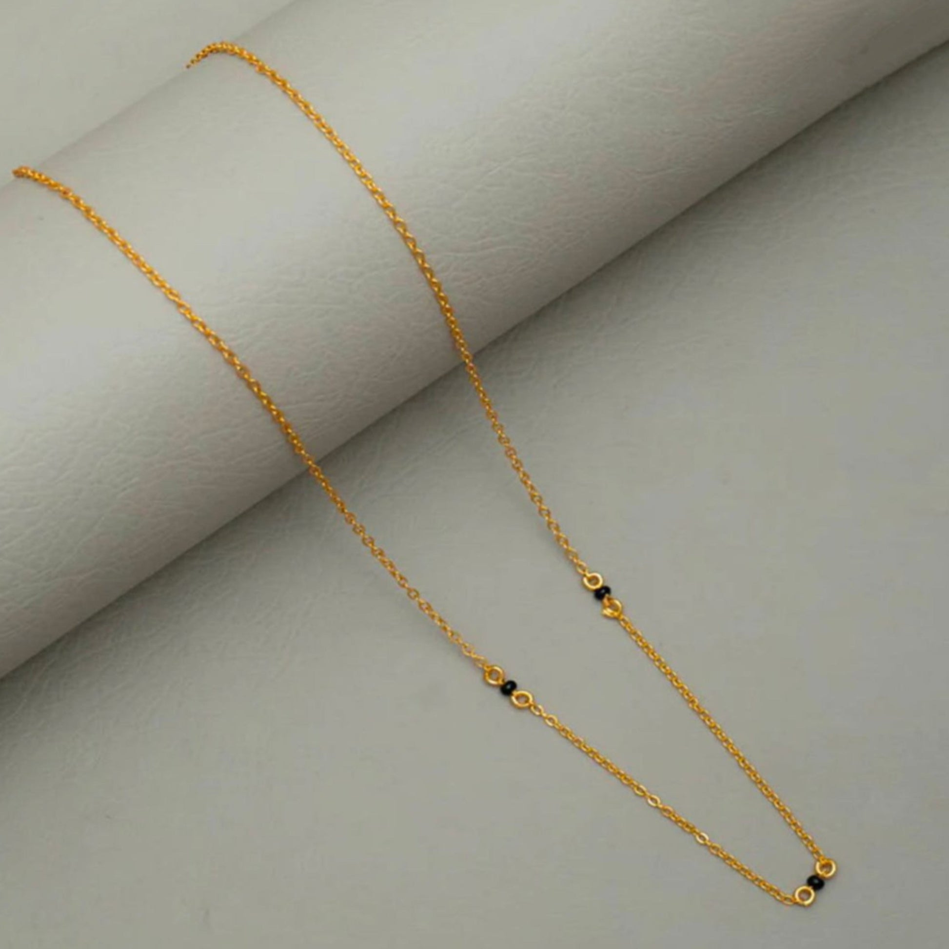Gold necklace on a light gray background