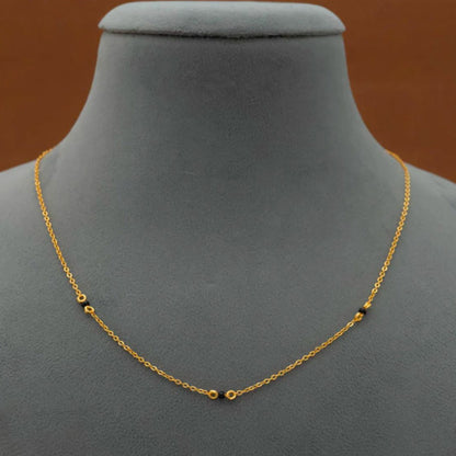 Gold chain necklace on a gray mannequin bust with a brown background