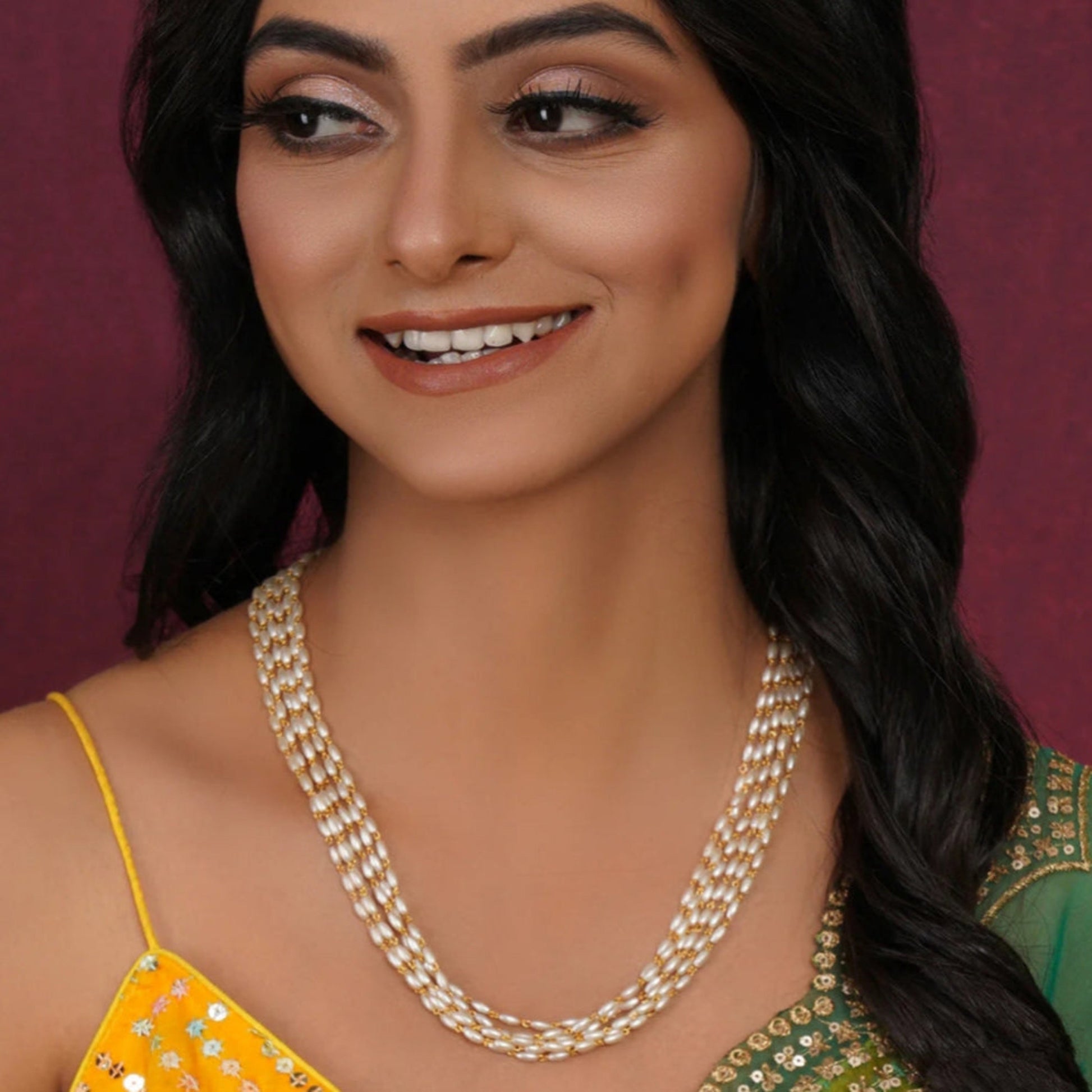 Woman wearing a pearl necklace with a blurred purple background