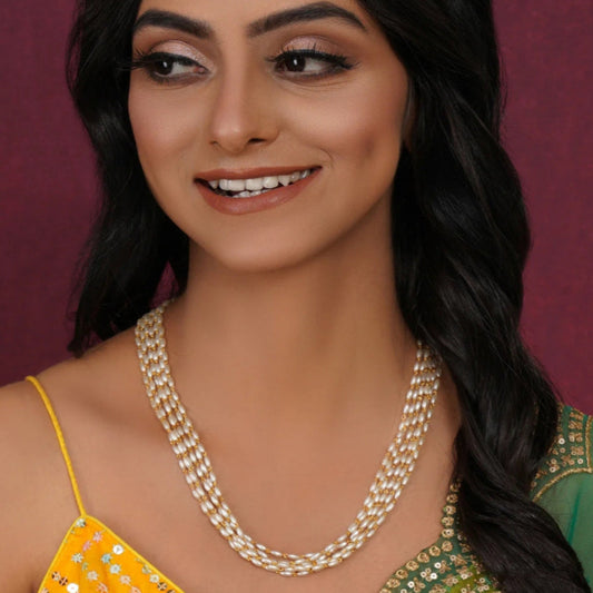 Woman wearing a pearl necklace with a blurred purple background