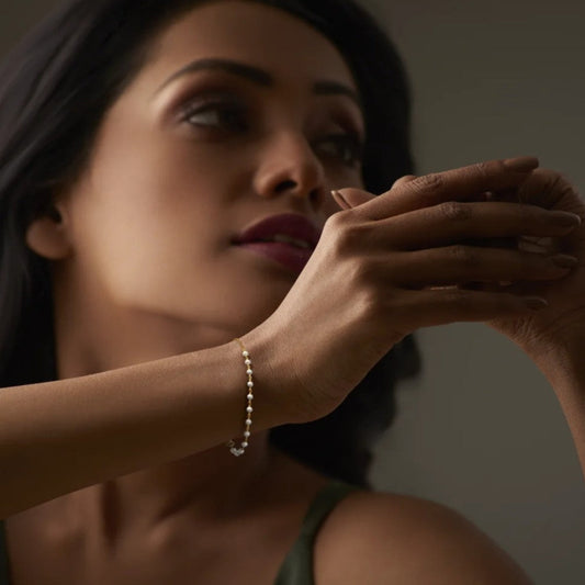 Woman wearing a pearl bracelet with a blurred background