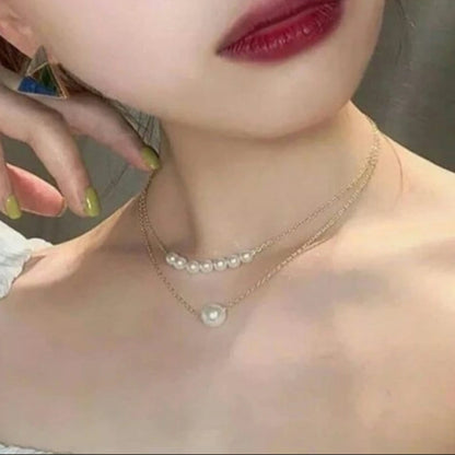 Close-up of a person wearing a pearl necklace with a blurred background
