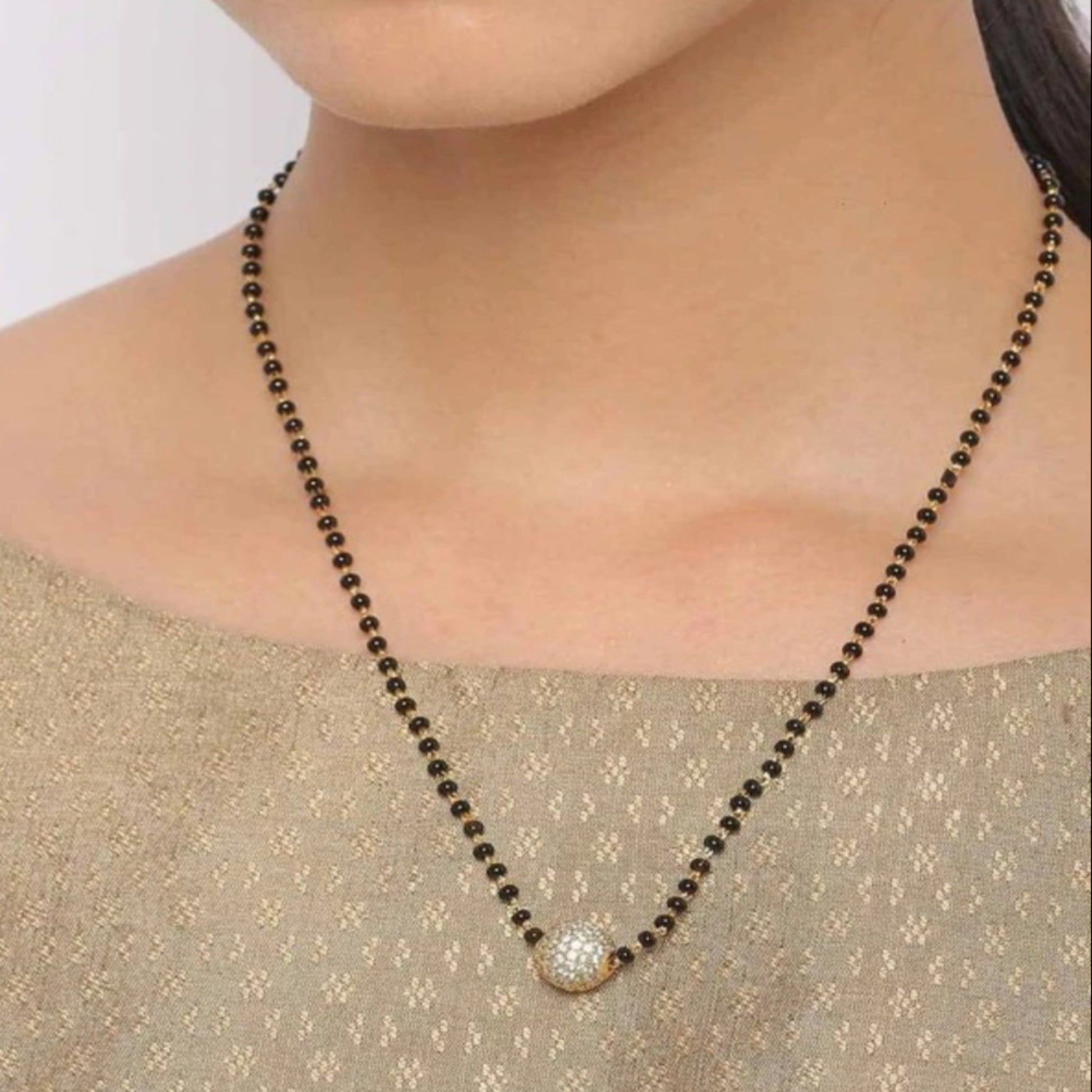 Necklace with a pendant worn by a person on a plain background