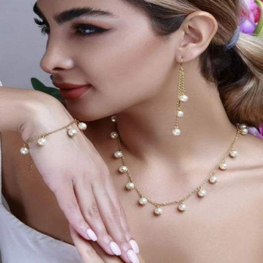 Woman wearing a pearl necklace and bracelet with a neutral background