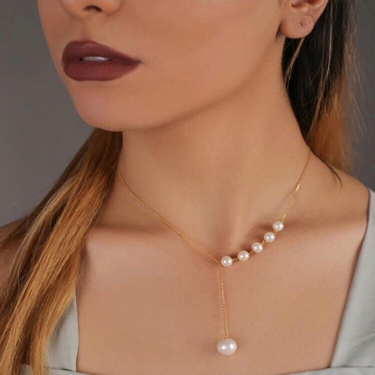 Pearl necklace worn by a model with a neutral background