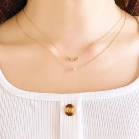 Gold necklace on a mannequin with a white top