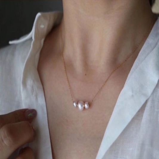 Pearl necklace worn by a person with a white shirt