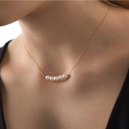 Pearl necklace on a person's neck with a blurred background