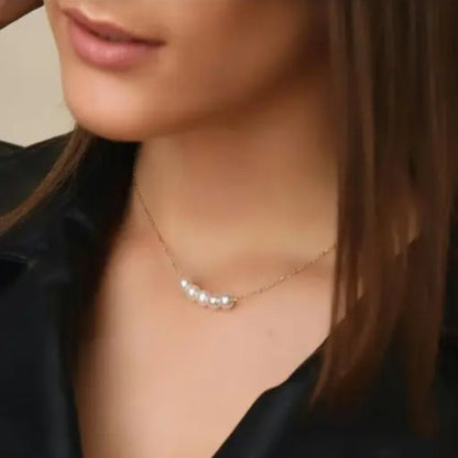 Pearl necklace worn by a person with a neutral background