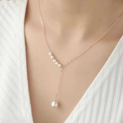 Pearl necklace worn by a person against a white background