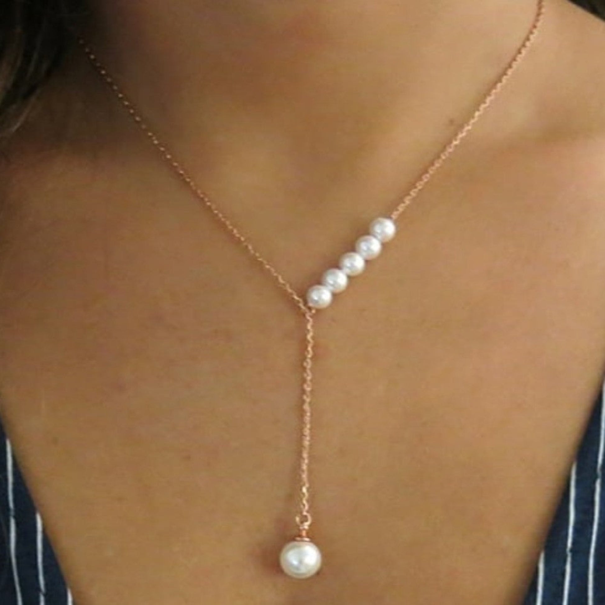 Pearl necklace with gold chain on a person's neck