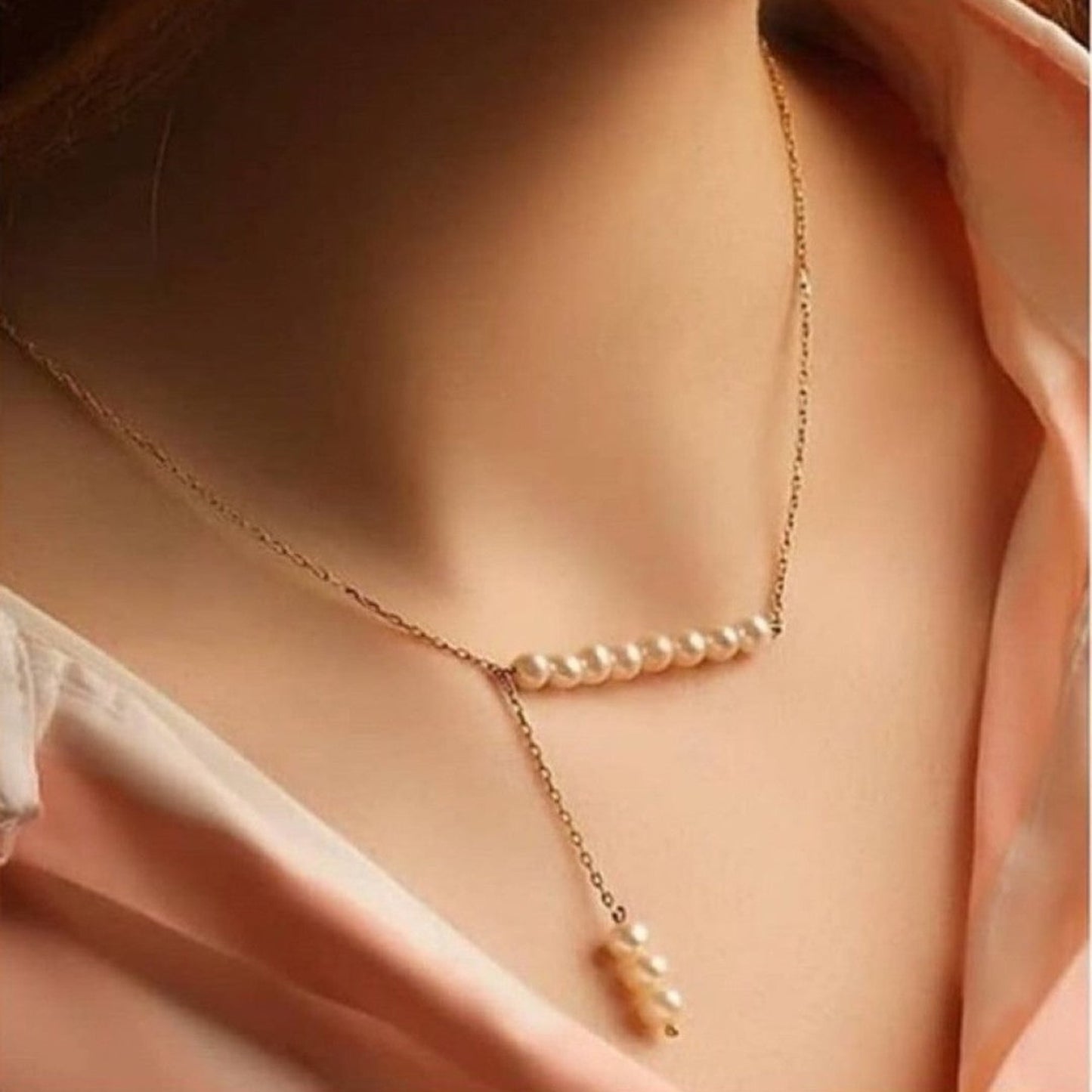 Pearl necklace on a person wearing a light pink top