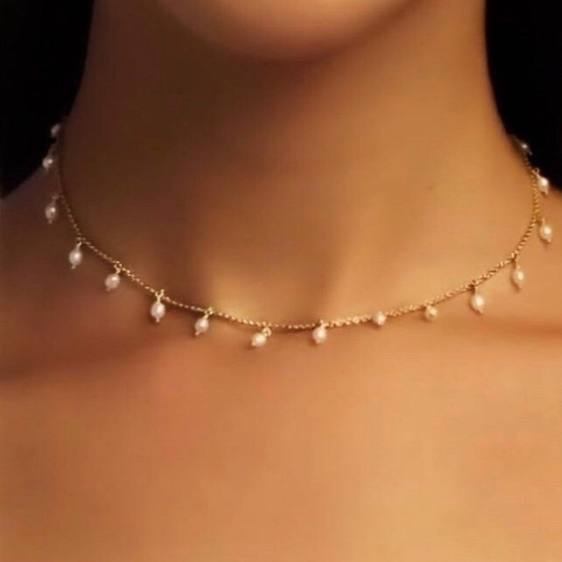 Pearl necklace on a person's neck with a blurred background