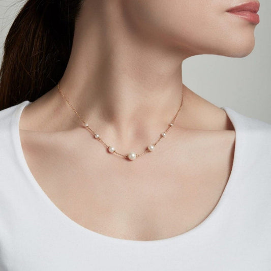 Pearl necklace on a model against a neutral background