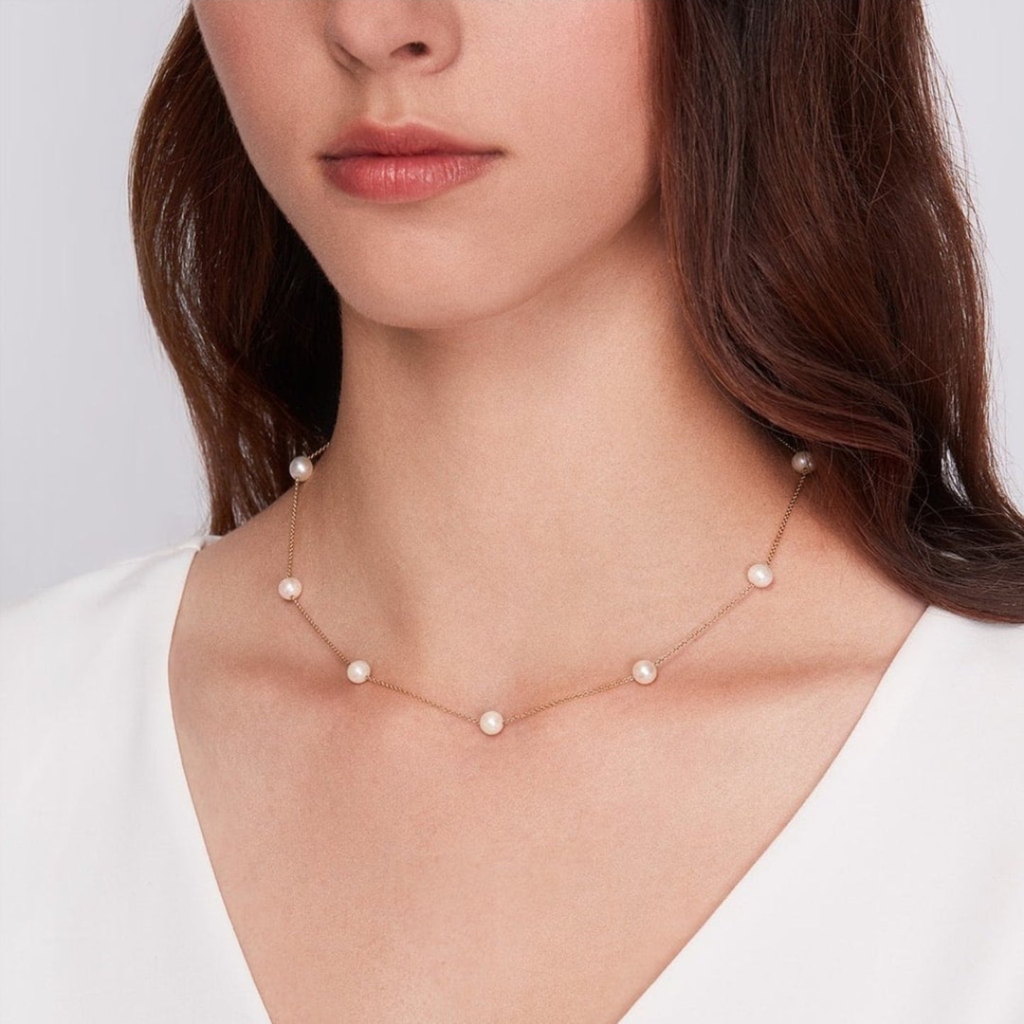 Pearl necklace worn by a model on a plain background