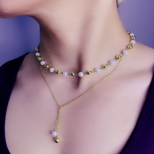 Close-up of a woman wearing two necklaces with a blurred background