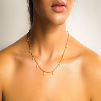 Close-up of a necklace on a person with a neutral background
