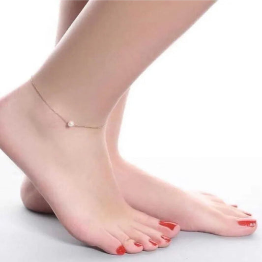 Ankle bracelet on a foot with a plain background