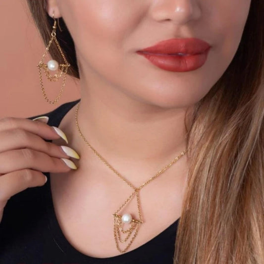 Close-up of a woman wearing a gold necklace with pearl accents, earrings, and red lipstick.