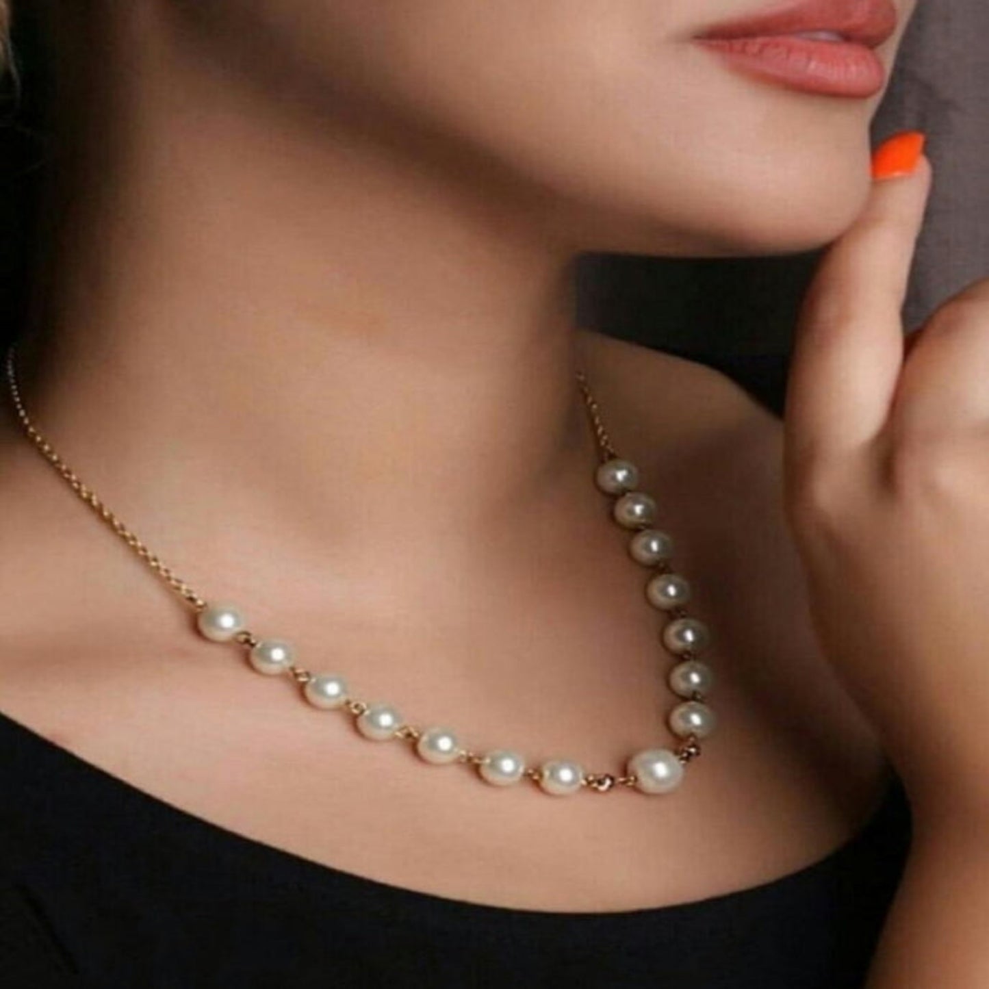 Pearl necklace worn by a model with a blurred background