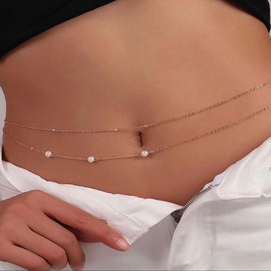 Close-up of a person wearing multiple thin gold chains with small pearls on a white background